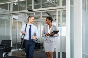 Mature businessman and black businesswoman going to work